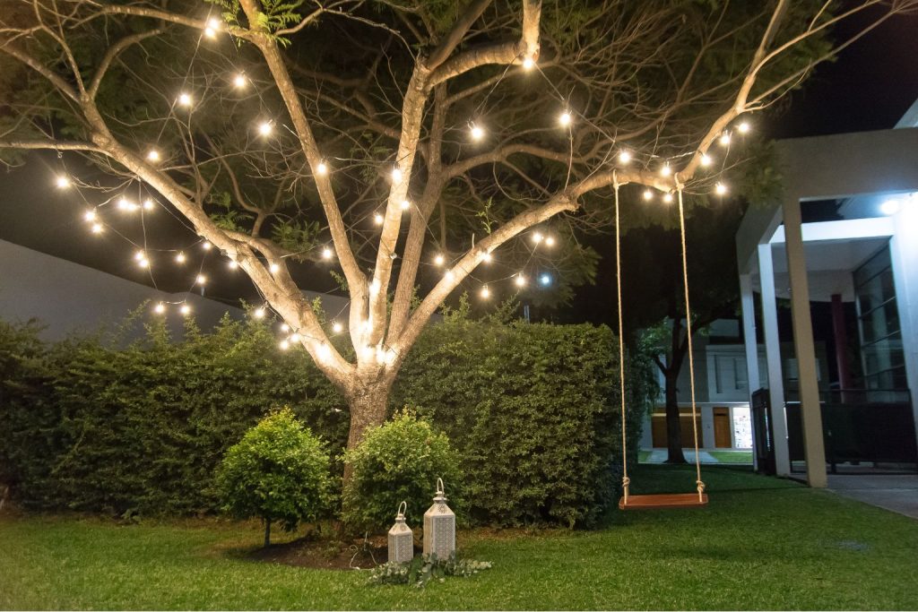Ambiente externo com balanço e luzes em árvore, representando o cuidado e a intenção no design com propósito.